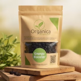 Packet of Organica premium organic dried cherries displayed on rustic wooden platforms with a natural blurred forest background, showing the deep dark texture of sun-dried cherries visible through the clear packaging window.