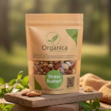 rganica Royal Mix stand-up pouch containing premium mixed dry fruits and nuts placed on a rustic wooden platform. Packaging shows organic almonds, walnuts, pistachios, and cashews through a transparent window with a green 'Stress Buster' label. Blurred natural outdoor background representing organic freshness from Gilgit Baltistan.
